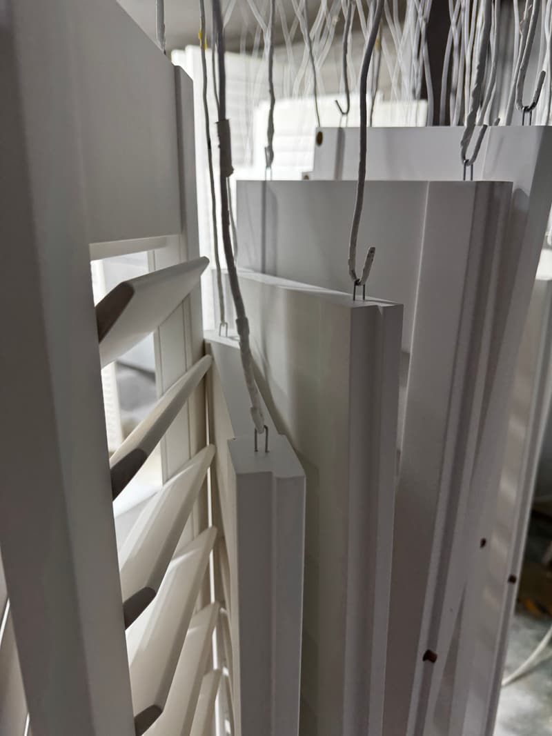 Painted shutter components hanging on the drying line