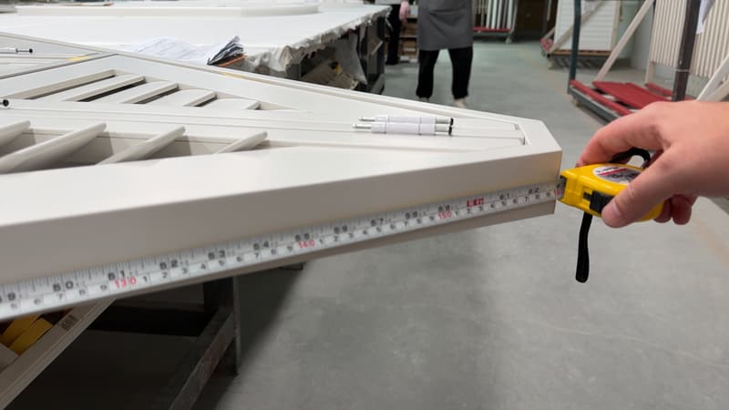 Checking the length of a finished shutter panel with a tape measure